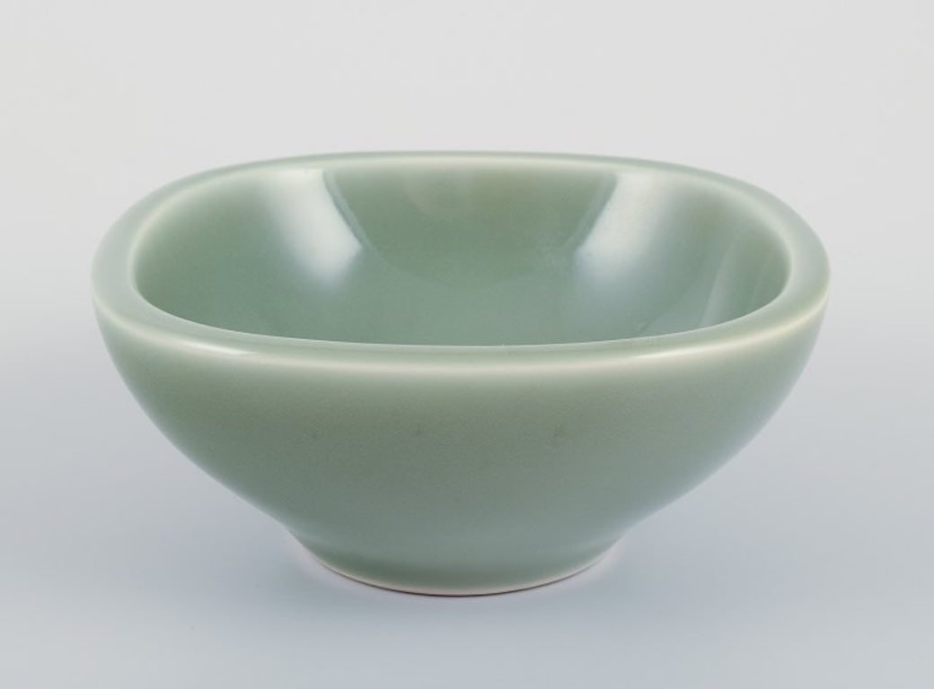 Nils Thorsson for Royal Copenhagen. Ceramic bowl in celadon glaze. Featuring a fish motif. Mid-20th: Nils Thorsson for Royal Copenhagen. Ceramic bowl in celadon glaze. Featuring a fish motif. Mid-20th century. Model number 1205. Marked. Perfect condition. First factory quality. Dimensions: D 13.0 cm 