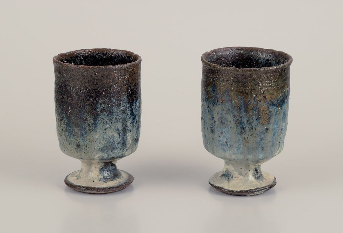 Gutte Eriksen, Denmark. Two cups in ceramic, raku technique, flowing lava glaze. Approx. 1960.: Gutte Eriksen, Denmark. Two cups in ceramic, raku technique, flowing lava glaze in blue-gray tones. Approximately 1960. Marked. Perfect condition. Dimensions: H 9.0 cm x D 6.0 cm. Gutte Eriksen (1918-