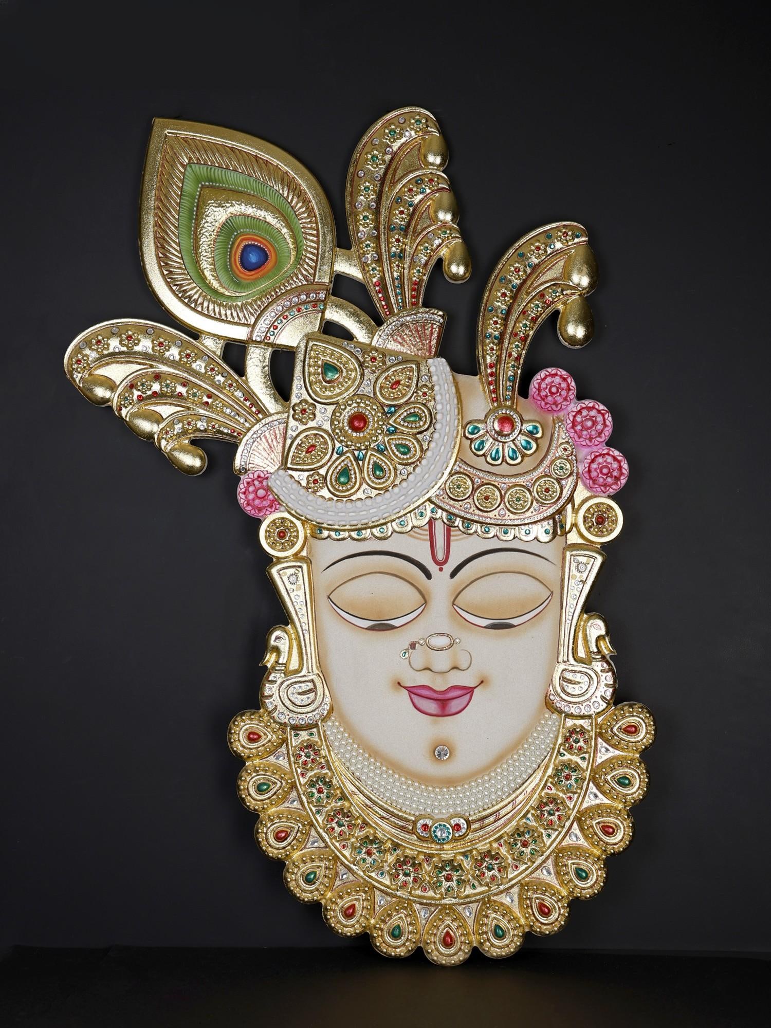48" Large Shrinathji Wall Hanging Statue with Gold Work: Description: The countenance of Krishna is often evoked in sacred poetry as "Mukhaaravinda"- the lotus face. This mesmerizing four-foot stone masterpiece captures the delicate and monumental beauty