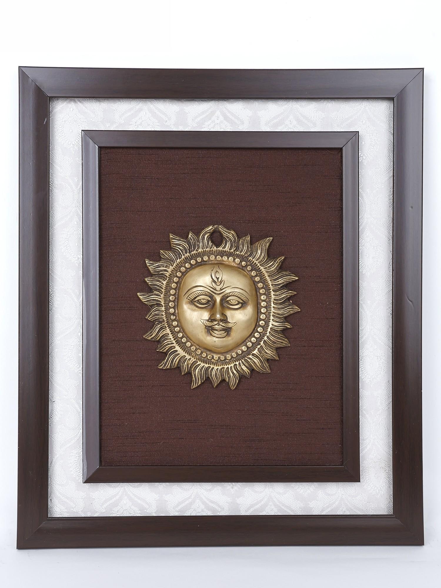 16" Lord Surya Wood Framed Brass Sculpture /Wall Hanging: Description: The source of life and positivity, Bhagwan Surya is revered in Hindu Vastu traditions as an essential sacred presence in any home. This artistic wall hanging brings the aura of the Sun wi