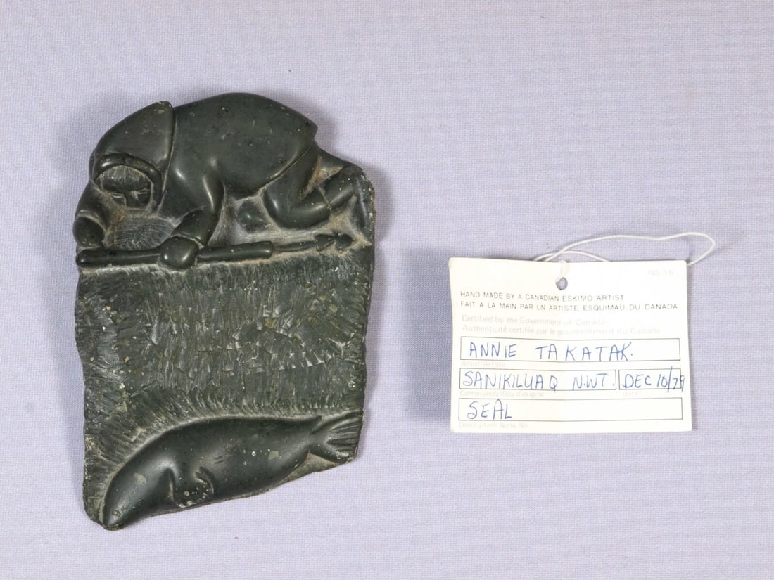 Inuit Canada Native Canadian Soapstone Carving Man Seal SIGNED Annie Takatak: This is a vintage Native American Eskimo Inuit Figurine. It was made by Annie Takatak, from Belcher Islands, Canada. The figurine is made from soapstone and is very unusual. It is a plaque with flat