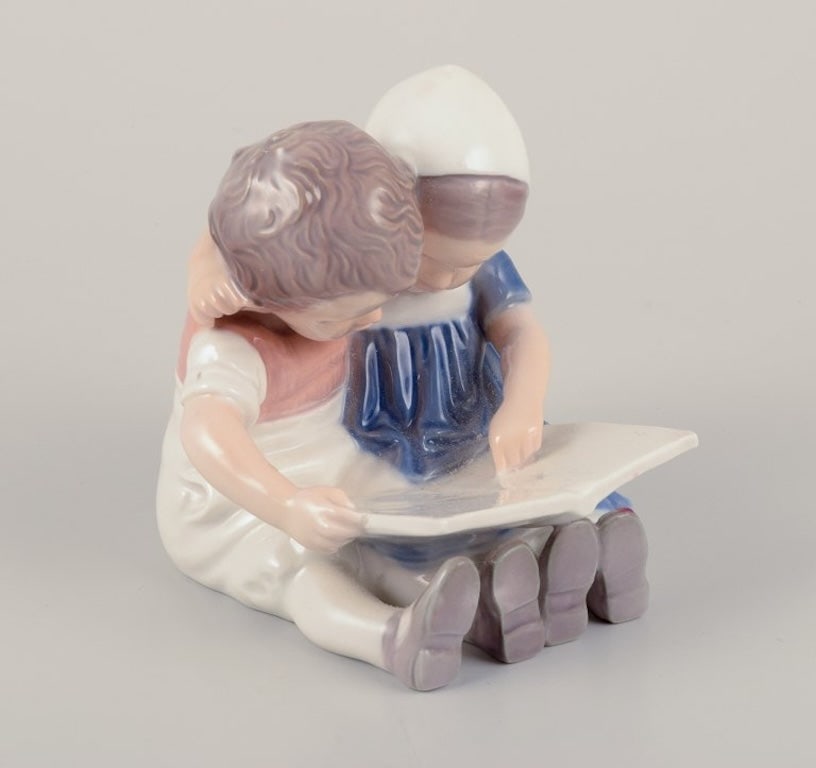 Bing & Grøndahl, Denmark. Porcelain figurine of reading children. Approximately 1930s. - 3