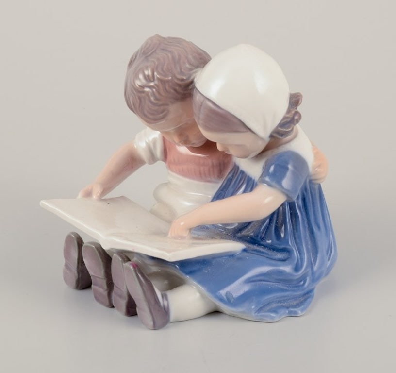 Bing & Grøndahl, Denmark. Porcelain figurine of reading children. Approximately 1930s. - 4
