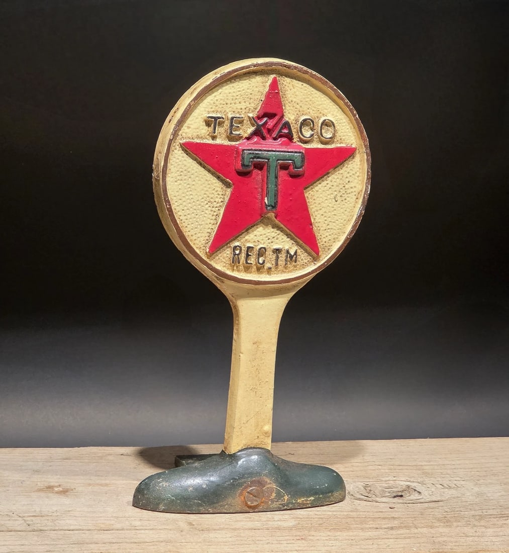 9.5" Texaco Cast Iron Doorstop Lollipop Sign Base Advertising: 9 1/2" Tall This is a heavy, cast iron Texaco "lollipop" reproduction sign base, highly popular today for use as a decorative doorstop. It features the iconic "Texaco" script in embossed lettering.