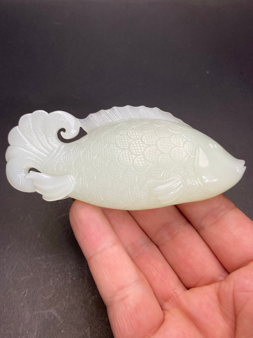 Hetian Jade Hand Carved Fish Pendnat: Title: Hetian Jade Hand Carved Fish Pendnat Origin: Chinese Date/Period: After2000 Materials: Hetian Jade Dimensions: 105x45x25.8(mm) 4.13x1.77x1.02(inches) Weight 0.32 lbs/147g Reserve: $750.00