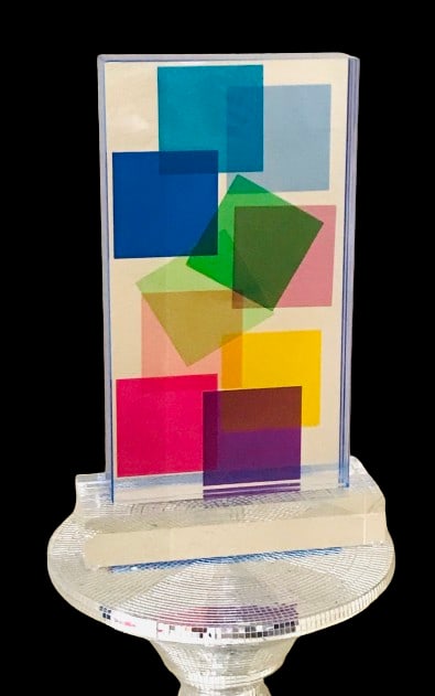Lucite Acrylic sculpture Multi Color by Grace Absi: A sculpture of a Lucite block handcrafted in the interiors with a geometric motif, laminated together on a clear, thick base, and hand-signed by the artist Grace Absi. It is in fine condition and