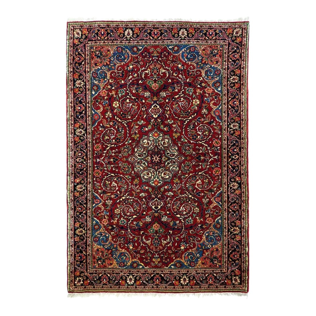 1940s Vintage Sarouk Rug 4'2'' x 6'6'': This vintage scatter combines the "American Sarouk" protocols of a red field decorated with floating floral sprays with an ecru volute-filled medallion and a larger, circumferential volute acanthus ou