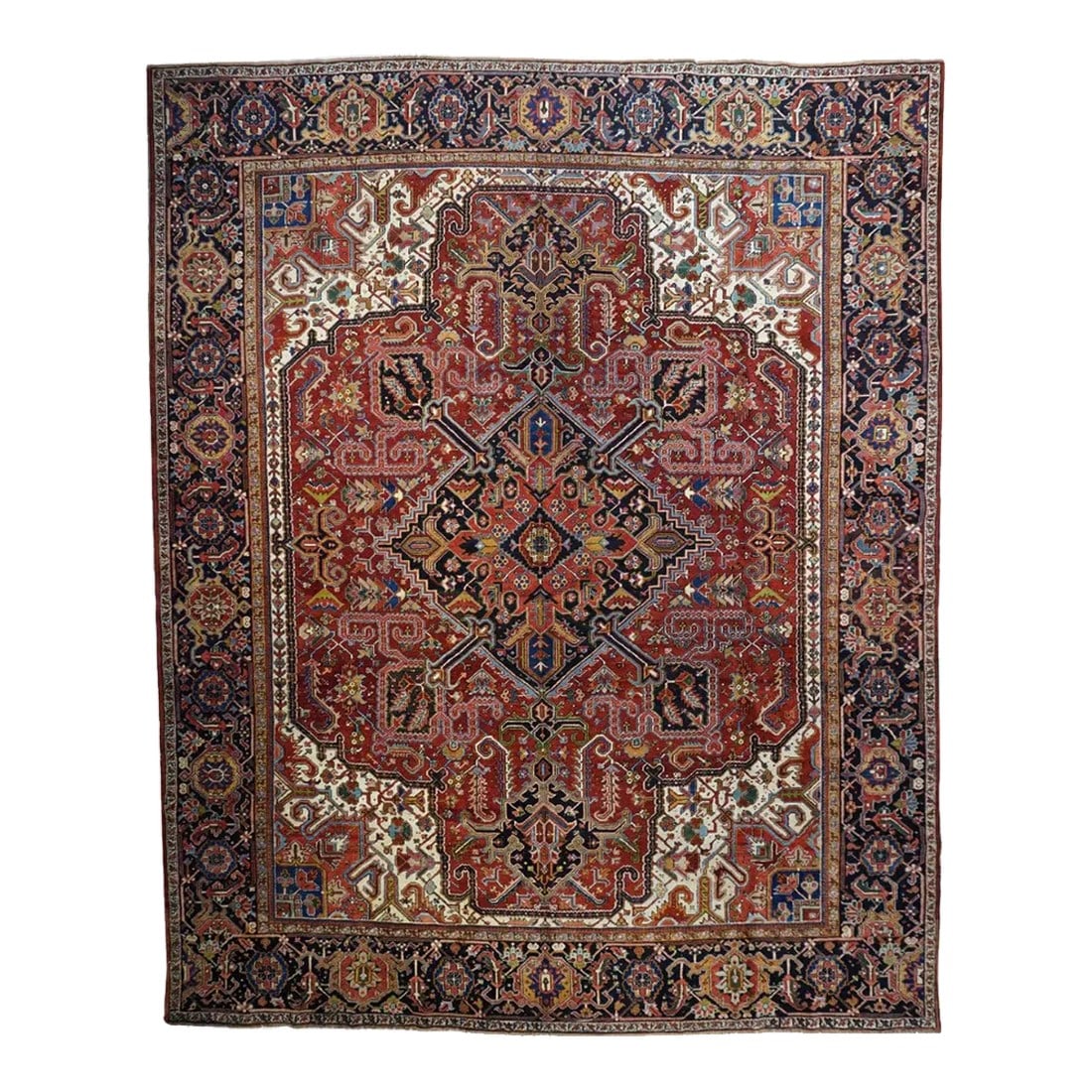 Vintage Heriz Rug 11'6'' X 14'1'': The ivory field reveals itself in the corners with quarter sub-medallion insets, and is mostly covered by he red quadrilobed field into which is keyed the navy diamond medallion. Barbed thick stiff ar