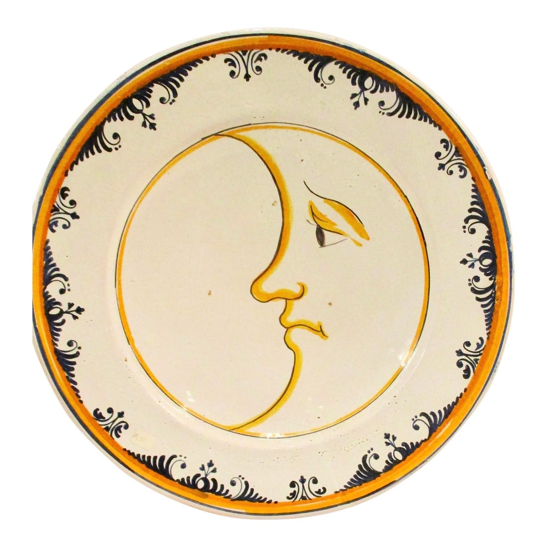 Man in the Moon French Faience Deep Dish Charger 70s: Wide and deep French faience wall decoration. Provincial cream glaze over a red clay body. Face of the Sun as central decoration. Border edged by orange and blue scrolling. The Back of the piece has a