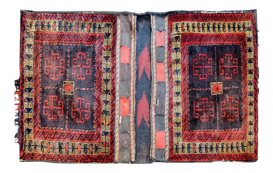 Early 20th Century Baluch Saddle Bag: A fantastic early 20th century Persian Baluch saddle bag with a beautiful woven geometric pattern woven in brown and crimson wool, flanked by a geometric border of red, gold, and brown wool.