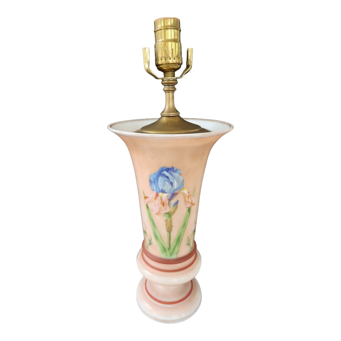 1940s Mid-Century Modern Hand-Painted Iris Satin Glass Table Lamp in Blush Pink With Brass Hardware: A charming mid-century vase-form table lamp in blush satin glass, hand-painted with a vivid blue iris and green stem decoration. The lamp is fitted with brass-tone hardware and has an elegant flared