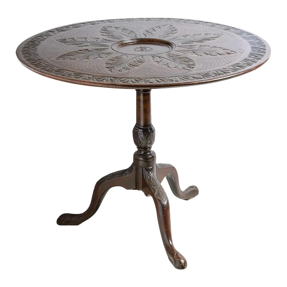 Antique English Mahogany Table With Carved Top: Unusual Antique English mahogany tilt top table which is intricately carved on the top with various leave patterns and a crisscross pattern. The center has a recessed area also carved. The base is