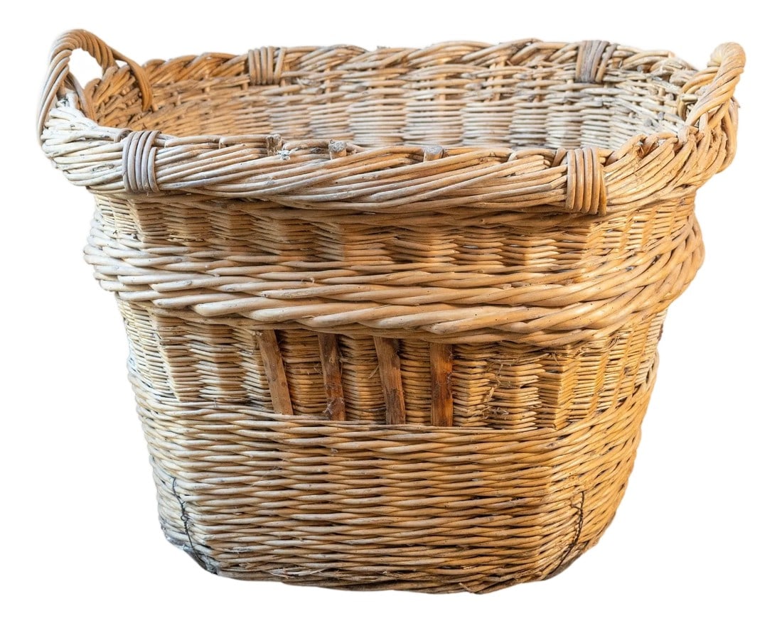 Early 20th Century French Wicker Grape Harvesting Basket: An early 20th-century French grape harvesting basket, skillfully handwoven from willow with a robust, time-worn presence. Originating from the vineyards of rural France, this basket was once a vital p