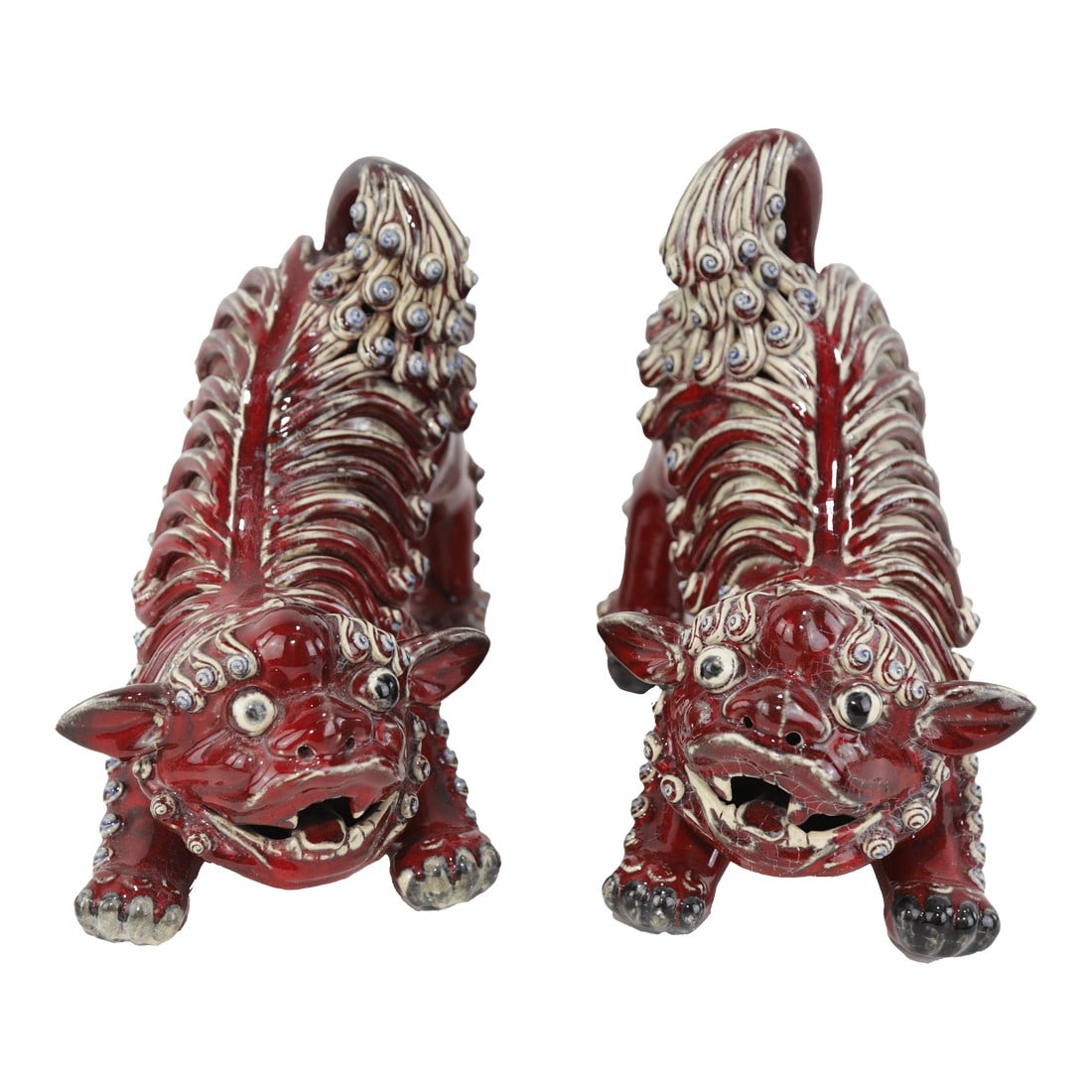 Pair of Chinese Shiwan Guangdong Red Porcelain Foo Dogs: A striking pair of Shiwan ceramic foo dogs hand-sculpted in dynamic poses with expressive faces and intricate detailing. Finished in a deep oxblood red glaze with ivory accents, these Foo Dogs embody