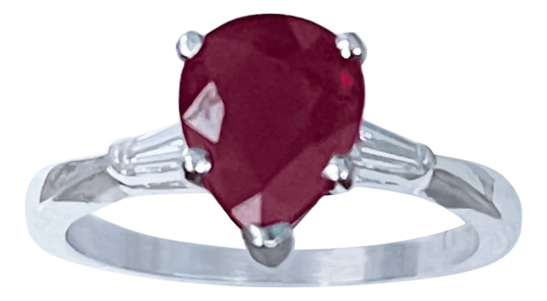 Pear Shape 2 Carat Treated Ruby & Diamond 14 Karat White Gold Ring: Pear Shape 2 Carat Treated Ruby & Diamond 14 Karat White Gold Ring Size 6.5 Its a treated ruby prong set 14 Karat White Gold: 3.5 gram Measurement 9X7 two diamond baguettes , one on each side of the