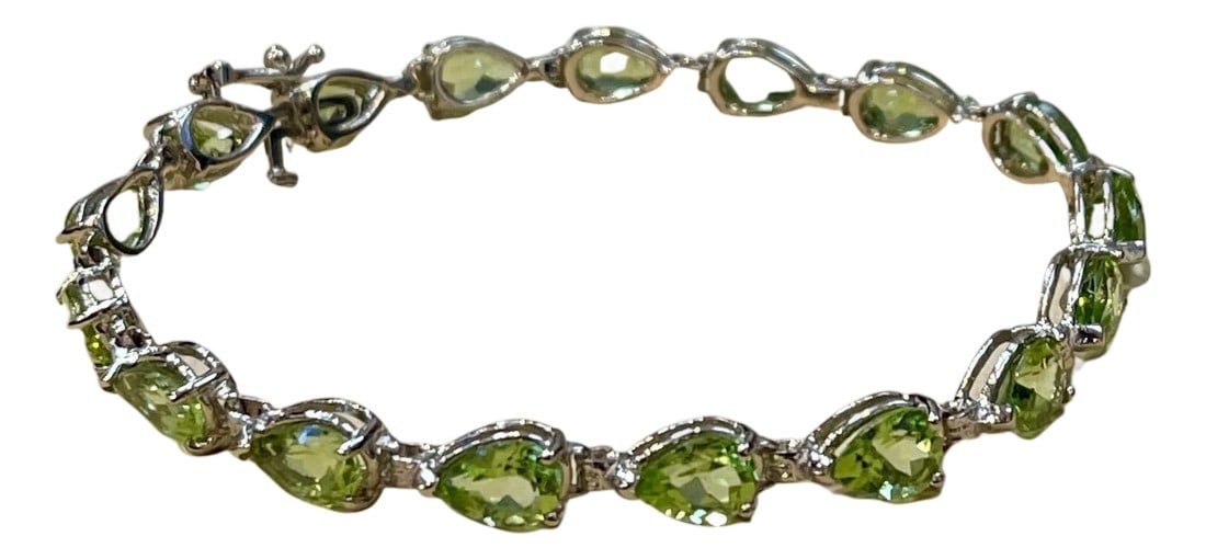 15 Carat Genuine Natural Peridot & Diamond Tennis Bracelet 14 Karat White Gold: This exceptionally affordable Tennis bracelet has 19 stones of Emerald cut Peridot Beautiful colors , very Vibrant Size of the stone is approximately 7X5 mm Each Peridot is spaced by two brilliant