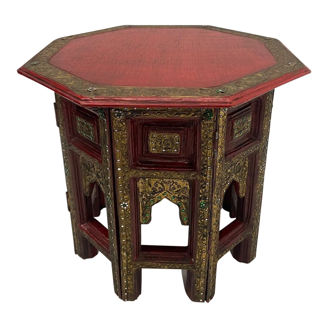 Hand Carved Red and Gilded Moroccan Side Table: Striking and glamorous Moroccan side table having a red painted octagonal top, carved folding base embellished with glass inset beads, floral decoration and gilding. Condition: Alterations: Original C