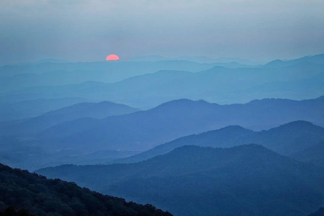2021 "End of the Day in the Blue Ridge Mountains. North Carolina" Modern Photography, Premium Archiv: As my wife and I were driving along the Blue Ridge Parkway north of Asheville NC, we could see through the trees a beautiful big red sun that was heading toward the horizon to end the day. We