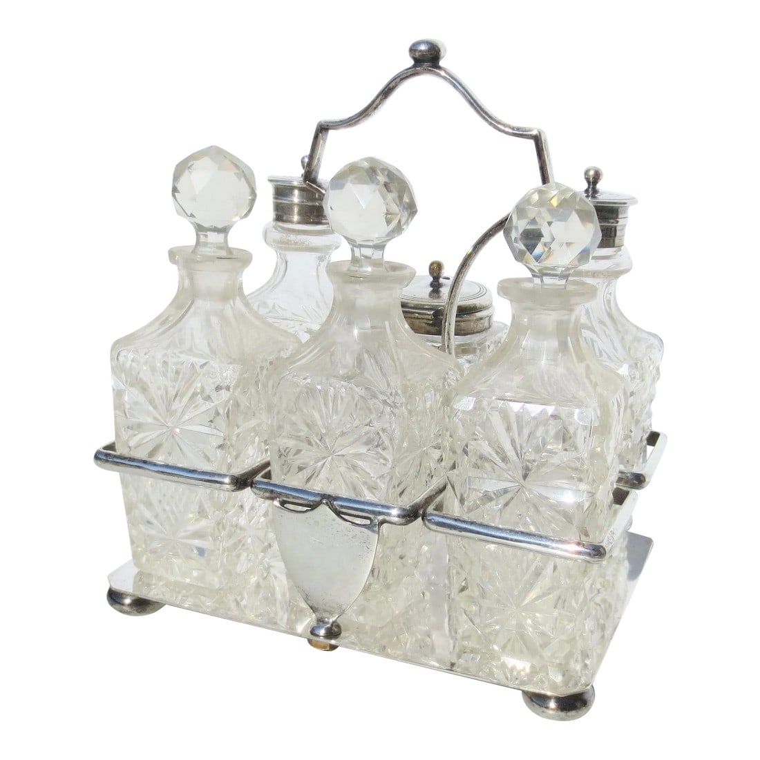 Late 19th Century Silverplate Cruet Set - 7 Pieces: Six set cruet set with cut faceted bottles and faceted stoppers. Circa 1880 with shield crest. Silver-plated caddy. decanters for oil, vinegar, salt, pepper, mustard, and sugar. No monogram and the ma