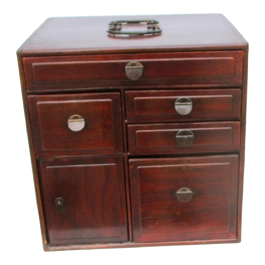 Antique Chinese Table Chest: Tabletop storage case with two top handles. The drawers with brass tabs. The whole is in a deep mahogany color. The assembly of various-sized drawers with the one cabinet door being on the bottom left