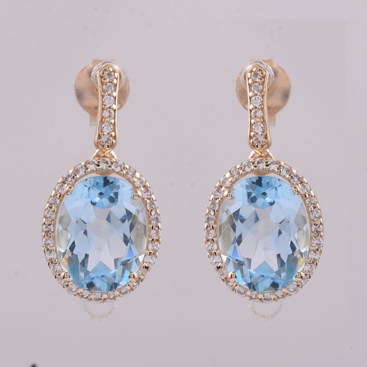 4.75 Ct Oval Blue Topaz 9K Gold Earrings: 4.75 Total Carat Blue Topaz 9K Gold Earrings Specifications: Total Weight 2.511 g Center Gemstone Blue Topaz Gemstone Carat Weight 4.45 Carats Gemstone Measurements 9X7 mm Additional Gemstones White