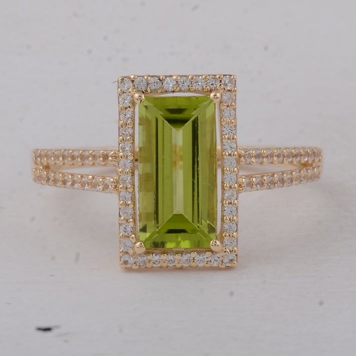 1.81 Ct Baguette Peridot 9K Gold Ring: 1.81 Total Carat Peridot 9K Gold Ring Specifications: Total Weight 2.14 g Center Gemstone Peridot Gemstone Carat Weight 1.49 Carats Gemstone Measurements 10X5 mm Additional Gemstones White Sapphire