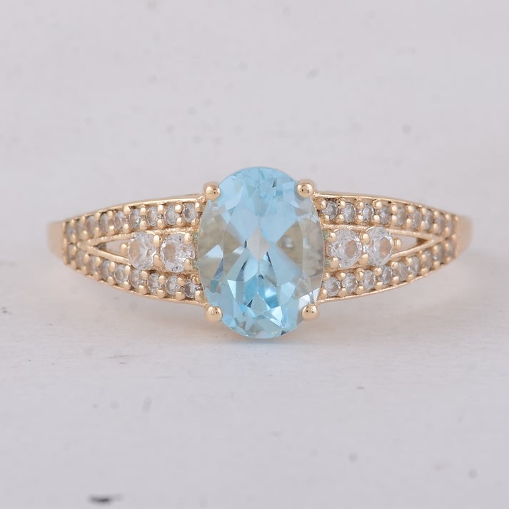 1.75 Ct Oval Blue Topaz 9K Gold Ring: 1.75 Total Carat Blue Topaz 9K Gold Ring Specifications: Total Weight 2.13 g Center Gemstone Blue Topaz Gemstone Carat Weight 1.47 Carats Gemstone Measurements 8X6 mm Additional Gemstones White