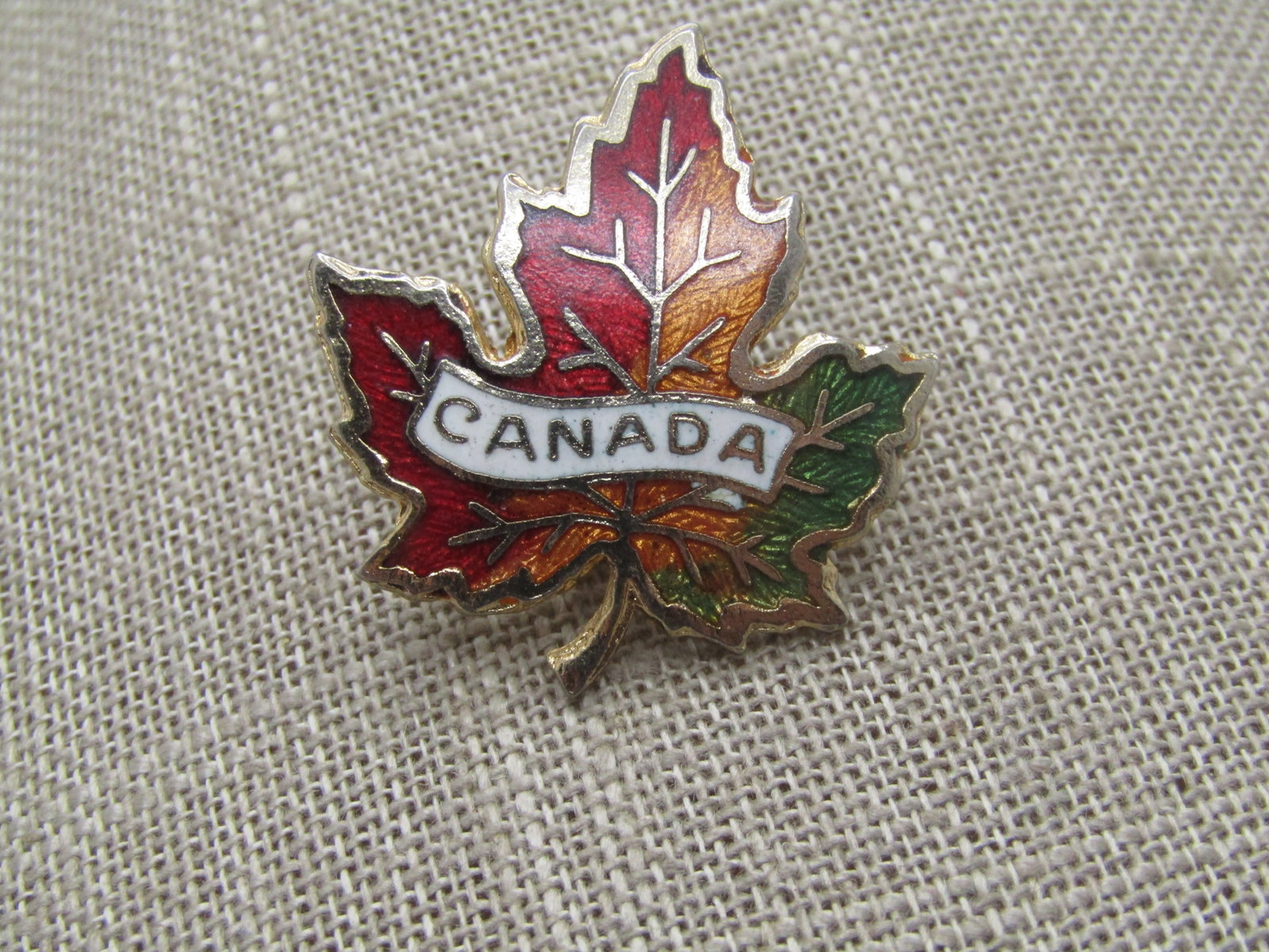 Vintage Guilloche Canada Maple Leaf Brooch, 1960's-1970's: Title: Vintage Guilloche Canada Maple Leaf Brooch, 1960's-1970's Description: Vintage Enameled/Guilloche Canada Maple Leaf Brooch, , 1960's-1970's. Gold tone with guilloche leaf in red, orange and gre