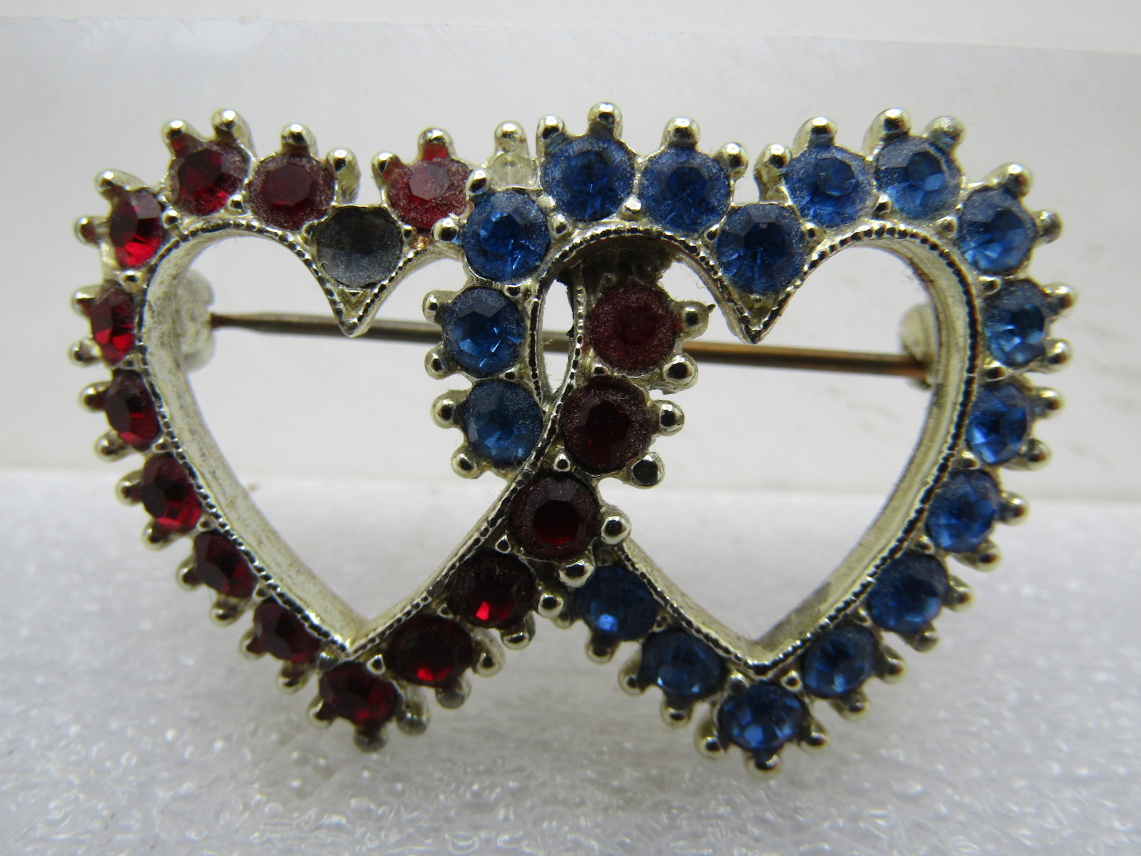 Vintage Red & Blue Heart Brooch, Intertwined, 1960's: Title: Vintage Red & Blue Heart Brooch, Intertwined, 1960's Description: Vintage Red & Blue Heart Brooch, Intertwined, 1960's. Gold tone with a 1" red heart and blue heart intertwined. One red stone w