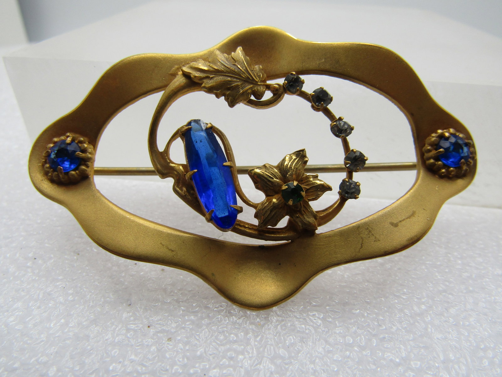 Vintage Blue & Clear Glass Brooch, 1920's, C-Clasp: Title: Vintage Blue & Clear Glass Brooch, 1920's, C-Clasp Description: Vintage Blue & Clear Glass Brooch, 1920's, C-Clasp. 2.5" wide and 1.75" tall with a floral and leaf design. Brassy gold done and 