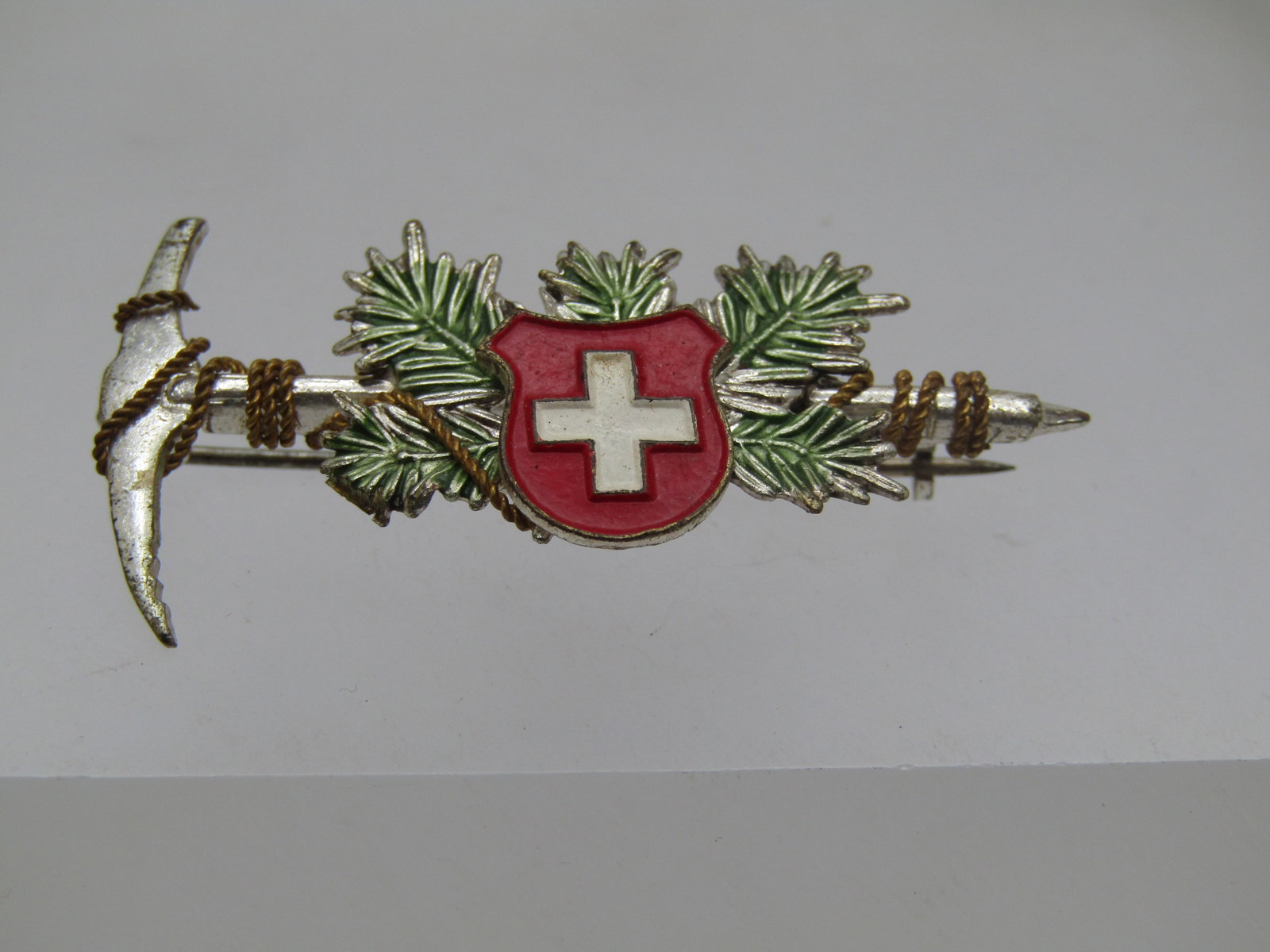 Vintage Enameled Swiss Hiking Brooch, 1960's, 1.75" Wide: Title: Vintage Enameled Swiss Hiking Brooch, 1960's, 1.75" Wide Description: Vintage Enameled Swiss Hiking Brooch, 1960's, 1.75" Wide and 1" tall. It is silver tone with a gold tone rope accent on