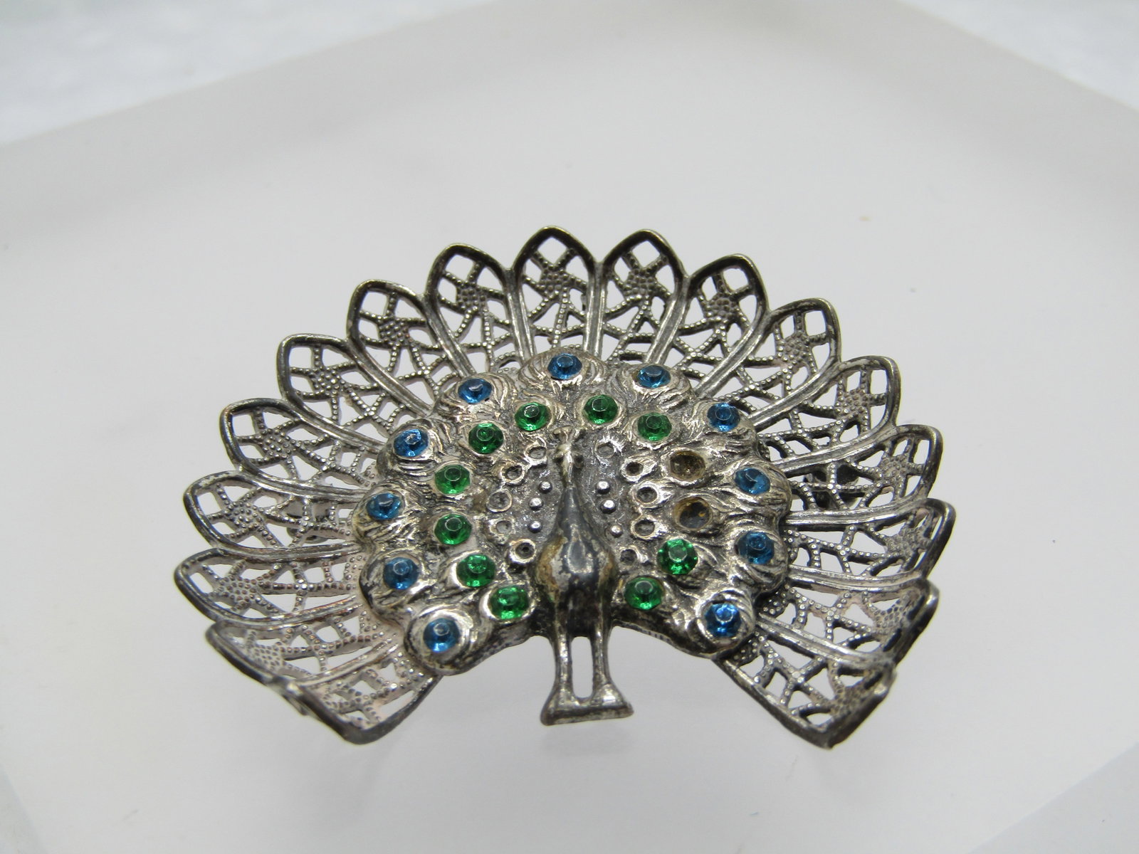 Vintage Silver Filigree Rhinestone Peacock Brooch, 1940's: Title: Vintage Silver Filigree Rhinestone Peacock Brooch, 1940's Description: Vintage Silver Filigree Rhinestone Peacock Brooch, 1940's. It has blue and green rhienstones - some were missing in the ph