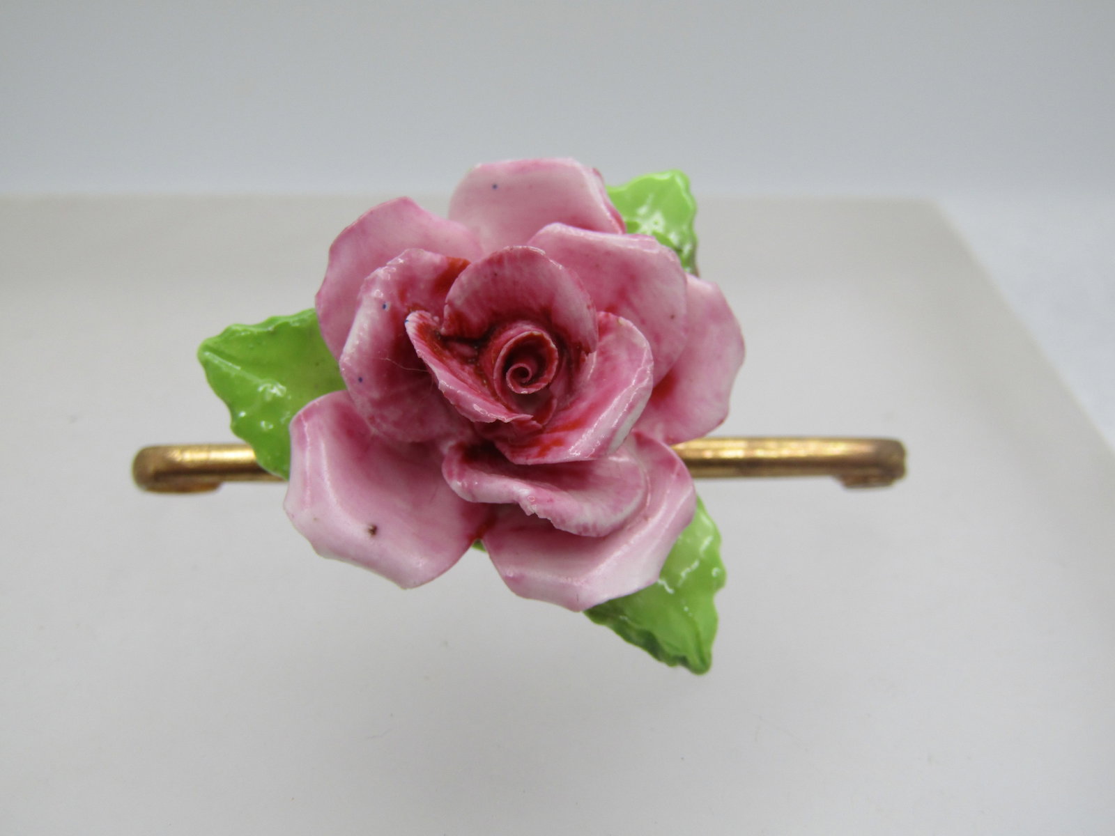 Vintage Porcelain Rose Brooch, England, 1950's-1960's: Title: Vintage Porcelain Rose Brooch, England, 1950's-1960's Description: Vintage Porcelain Rose Brooch, England, 1950's-1960's. The rose has three green peaves and a 3-d pink shaded painted rose blos