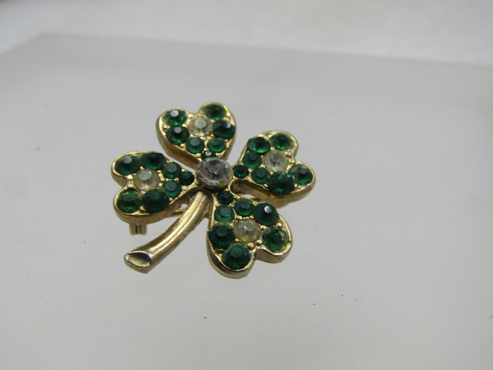 Vintage Green & Clear Rhinestone Shamrock Brooch, 1940's-1950's: Title: Vintage Green & Clear Rhinestone Shamrock Brooch, 1940's-1950's Description: Vintage Green & Clear Rhinestone Shamrock Brooch, 1940's-1950's. 1", gold tone metal with four heart-shaped ptals an
