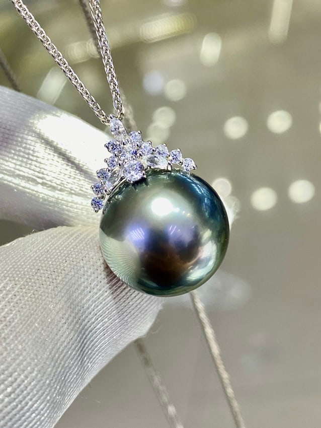 18K white gold Tahitian pearl pendant (chain not included): Title: 18K white gold Tahitian pearl pendant (chain not included)Description: This pendant features an 18K white gold thick setting carrying a nearly 15mm Tahitian pearl, showcasing a pure and translu