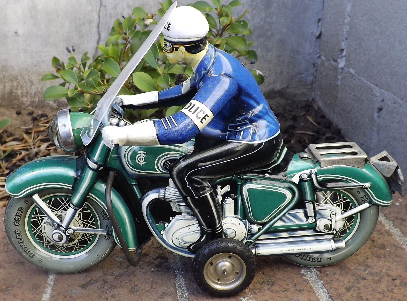Tippco Police Motorcycle with battery operated headlight.This is the much rarer version that has a: Tippco Police Motorcycle with battery operated headlight.This is the much rarer version that has a spring loaded contact activated by the friction motor producing a "siren effect" and making the headl