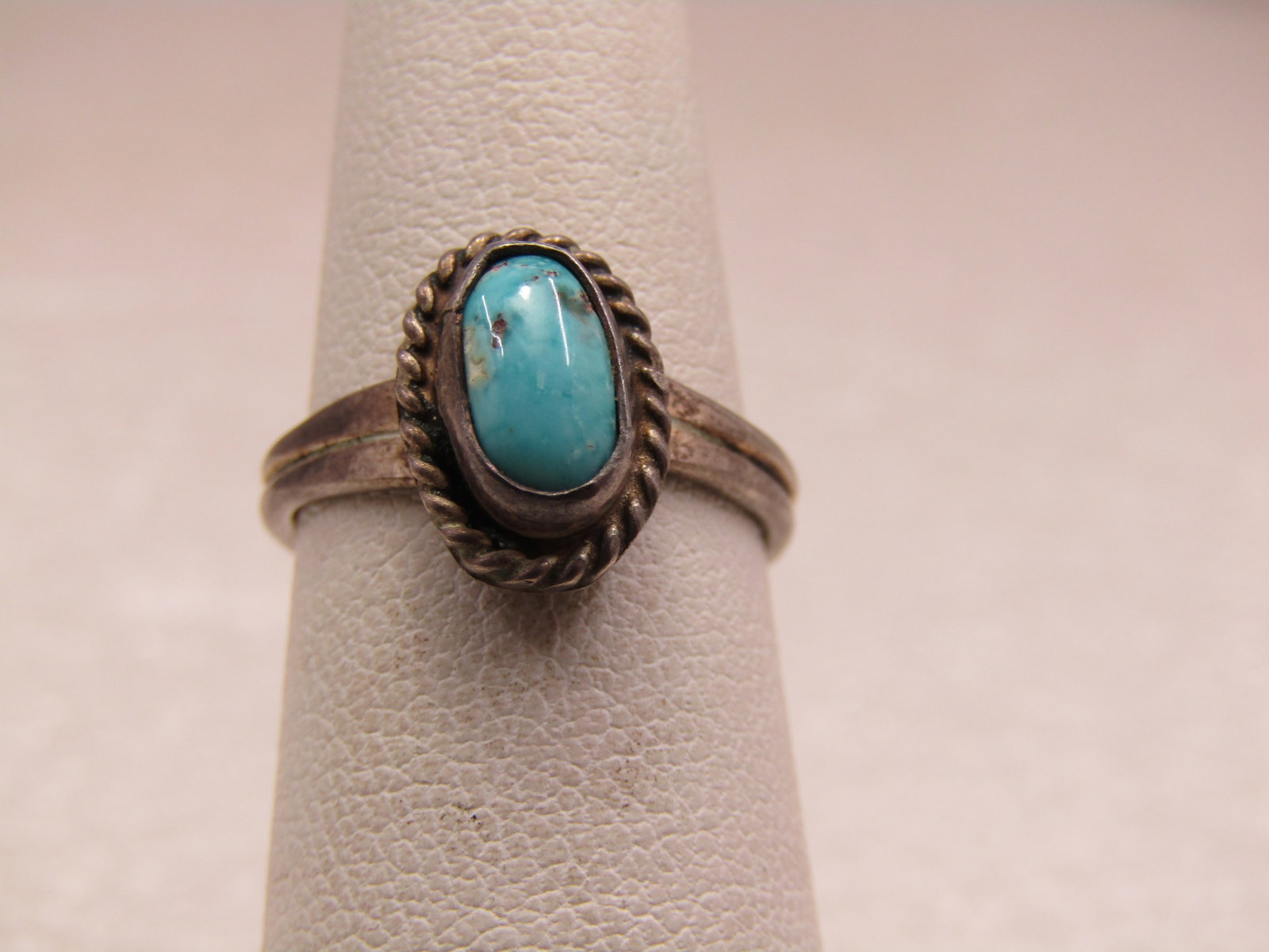 Vintage Sterling Southwestern Turquoise Ring, Sz. 5.25, 1960's-1970's: Vintage Sterling Southwestern Turquoise Ring, Sz. 5.25, 1960's-1970's. The ring has an oval setting on top that is appx. 11mm down the finger and 8mm across framed with a rope accent. Inside that fram