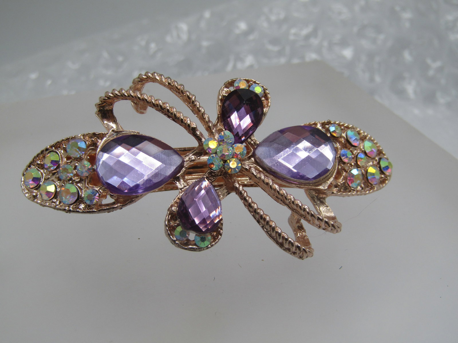Rose Gold AB Rhinestone Barrette, Amethyst Colored, 2.75": Rose Gold AB Rhinestone Barrette, Amethyst Colored, 2.75" by 1.5" tall. This has honeycomb acrylic rhinestones set on the top in lighter and darker shades with a blossom int he center of a double diag