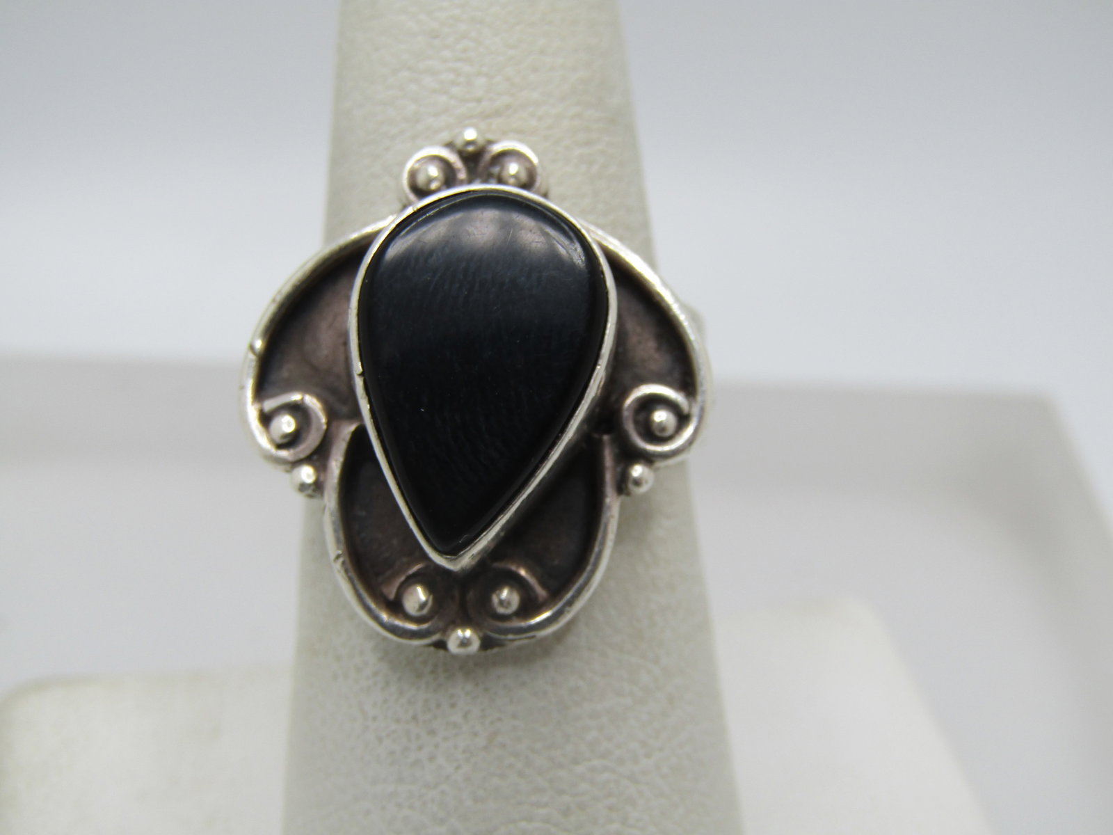 Vintage Sterling Southwestern Onyx Ring, Sz. 7.5, 1970's-1980's: Vintage Sterling Southwestern Onyx Ring, Sz. 7.5, 1970's-1980's. Tear-drop stone that is bezel-set and appx. 15.5mm by 10.5mm set in a wider scrolled based with bead accents. The ring top is appx. 22m