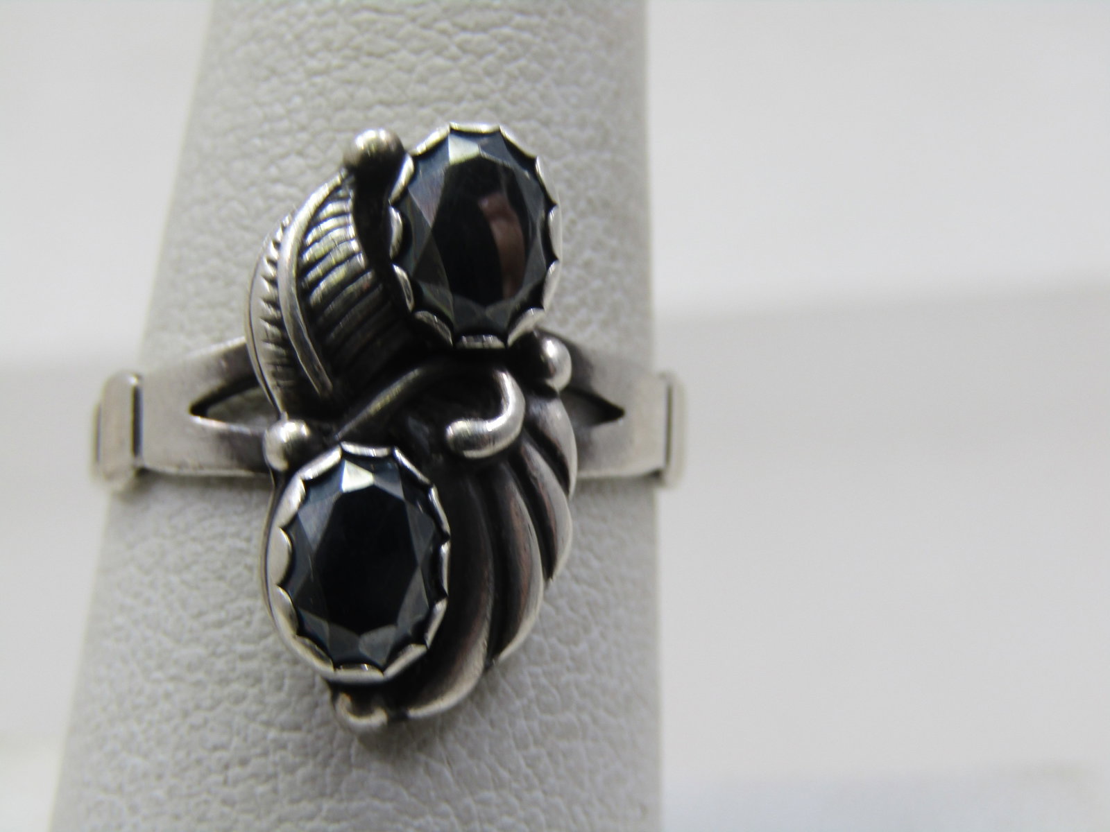 Vintage Sterling Southwestern Hematite Ring, Sz. 8, Signed WM: Vintage Sterling Southwestern Hematite Ring, Sz. 8, Signed WM. The stones are oval and appx. 6mm by 4.5mm in a bezel that has a scalloped edges. There is feather accent on one side and a wing on the o
