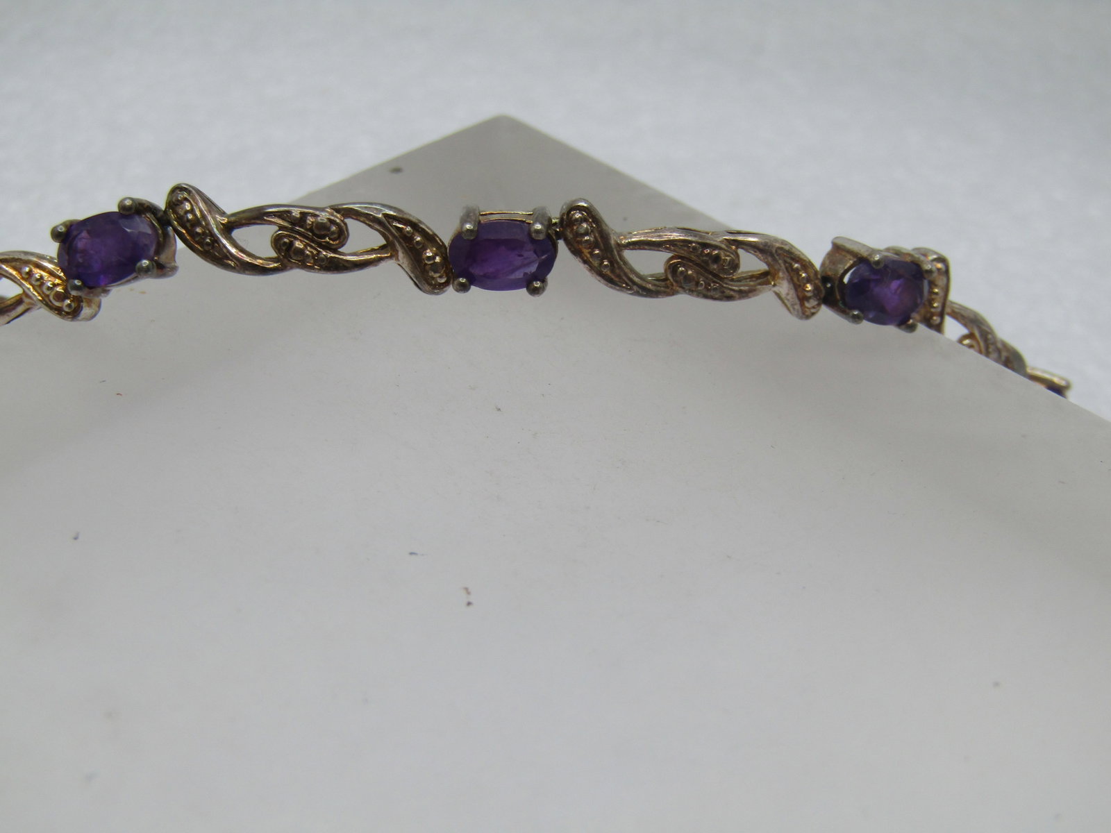 Vintage Amethyst Tennis Bracelet 7.25", Illusion Box Clasp, Safety Clips, 1980's-1990's: Vintage Amethyst Tennis Bracelet 7.25", Illusion Box Clasp, Safety Clips. 1980's-1990's This is silver plated with amethyst stones that are appx. 6mm by 4mm. This does test with silver content but are