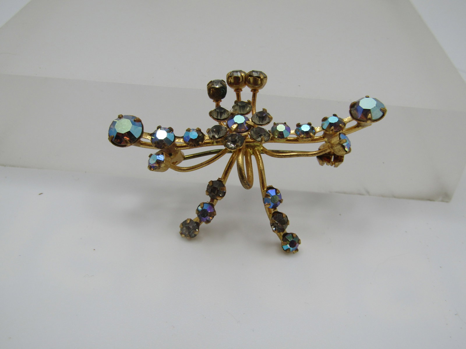 Vintage Austrian Crystal AB Brooch, 2", 1940's-1950's: Vintage Austrian Crystal AB Brooch, 2", 1940's-1950's. It has a 2" wide design with a two staggered lengths with aurora borealis crystal stones going left to right and a blossom in the center with thr