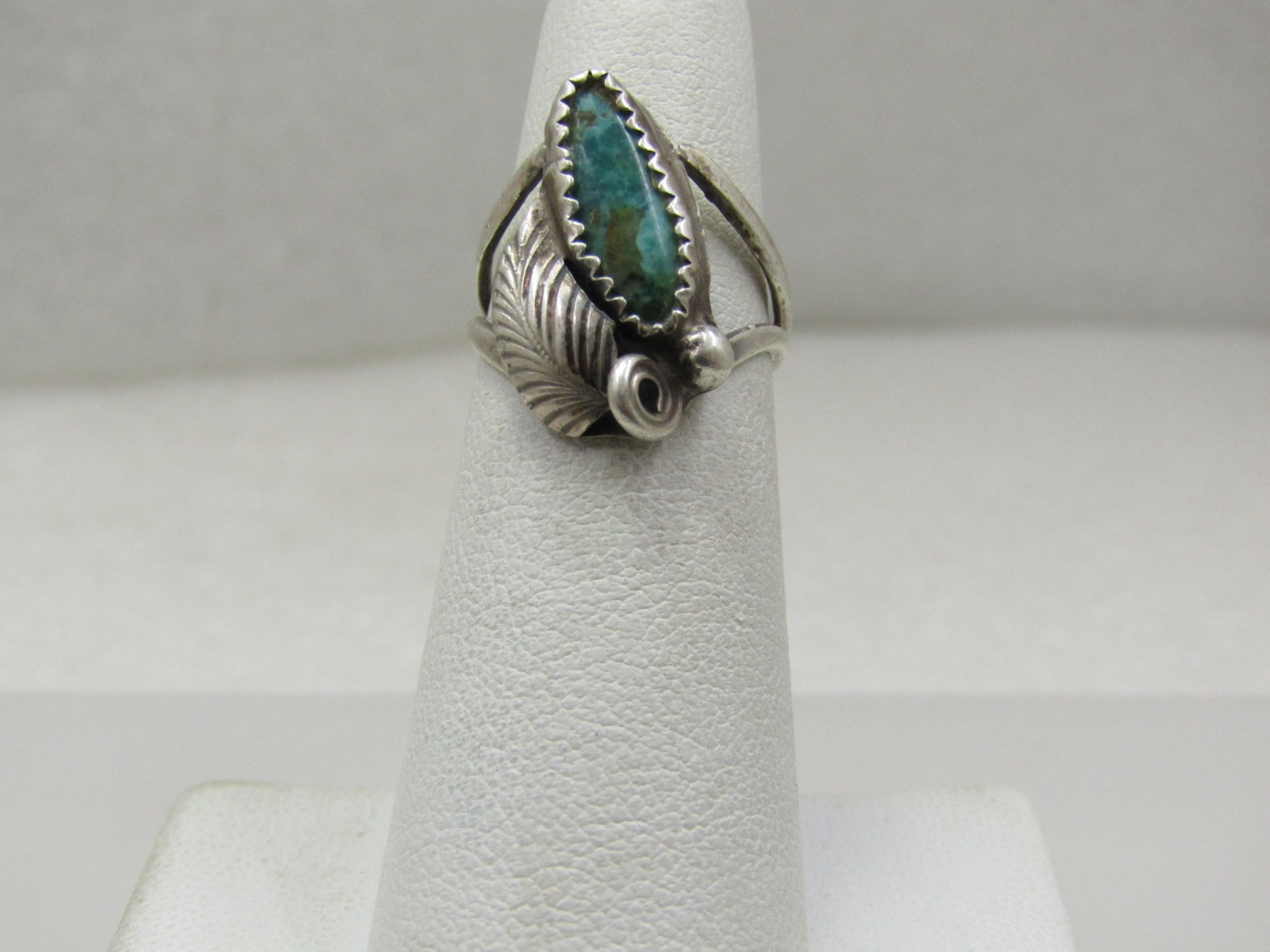 Vintage Sterling Southwestern Turquoise Feather Ring, Sz. 4.75: Vintage Sterling Southwestern Turquoise Feather Ring, Sz. 4.75. T his has an appx. 14.5mm by 6mm sawtooth bezel-set turquoise stone with a bead (raindrop) and feather accent. The top of the ring is ap