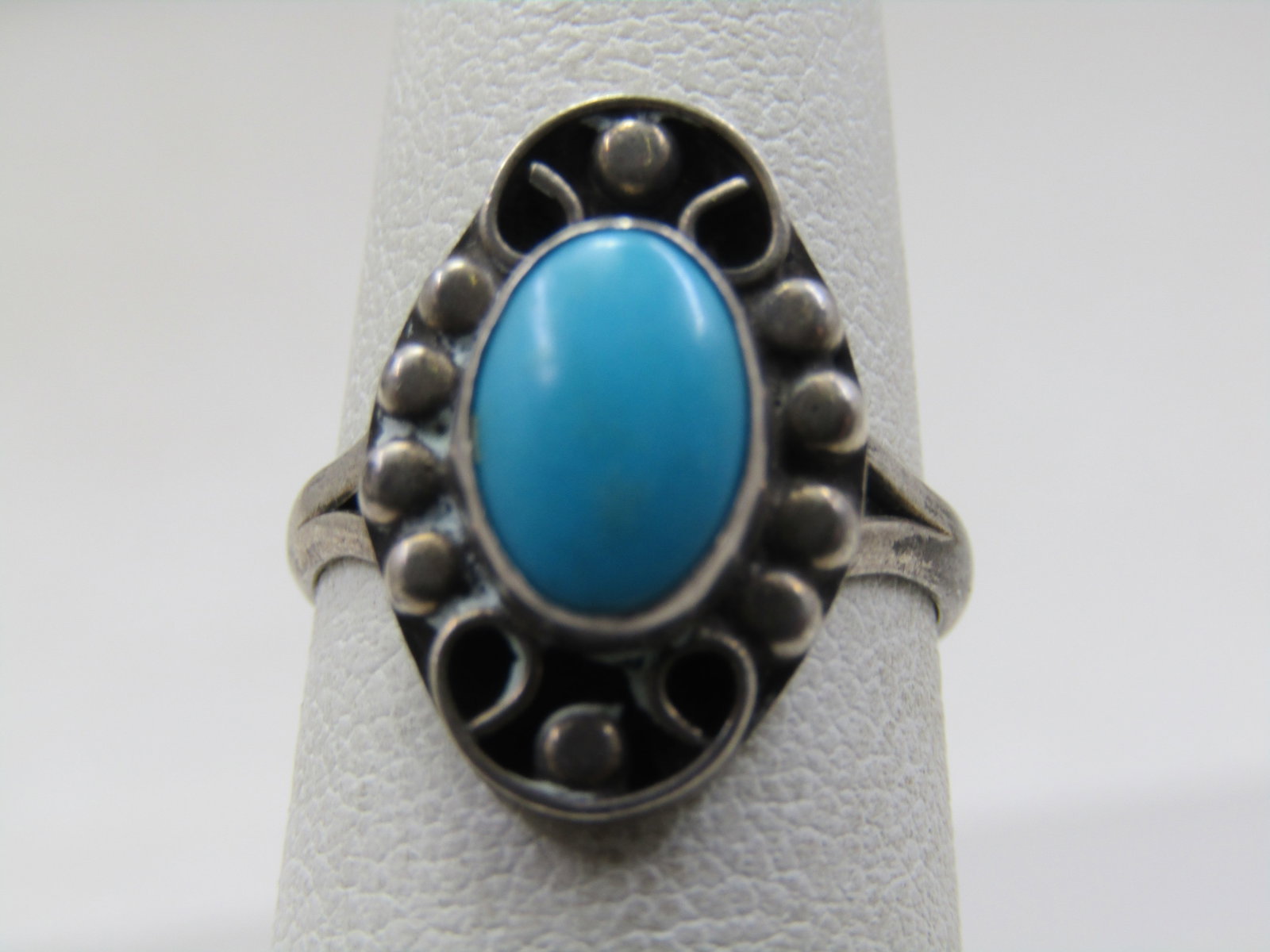 Vintage sterling Southwestern Faux Turquoise Ring, Sz. 5: Vintage sterling Southwestern Faux Turquoise Ring, Sz. 5. this has a scrolled top with beaded accents and a raised bezel-set oval turquoise created stone, likely resin. It is appx. 9.5mm by 7mm. It ha