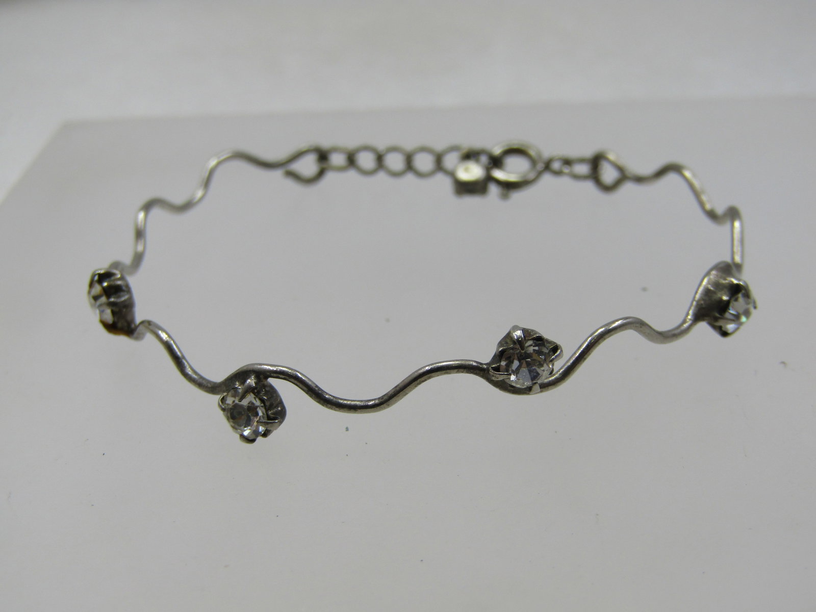 Vintage Clear Rhinestone Wavy Bracelet, 6.25": Vintage Clear Rhinestone Wavy Bracelet, 6.25". Silver Tone wavy band bracelet with 4mm round clear rhinestones set on the bracelet and one at the end of the chain at the spring clasp. This can be