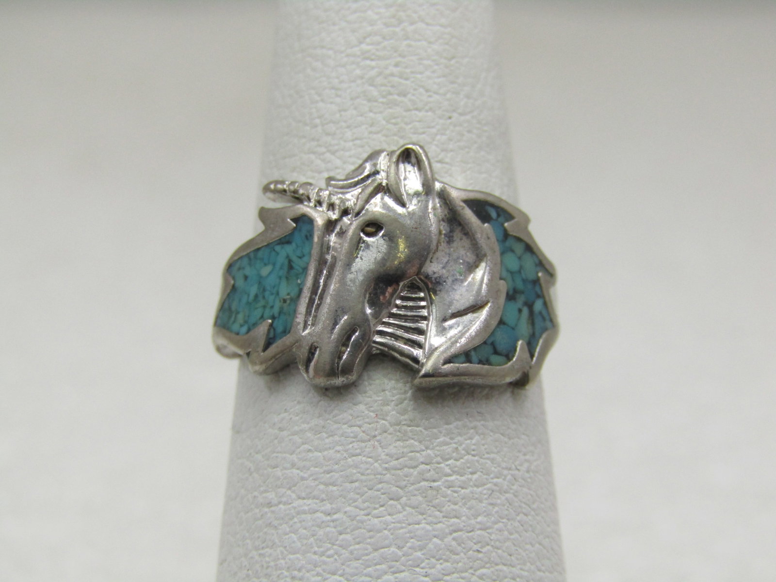 Vintage Turquoise Chip Unicorn Ring, Sz. 5. 1970's-1980's: Vintage Turquoise Chip Unicorn Ring, Sz. 5. Youth ring that is silver tone with turquoise colored inlaid chips on each side of the unicorn. head. The ring is appx. 12mm down the finger on top and
