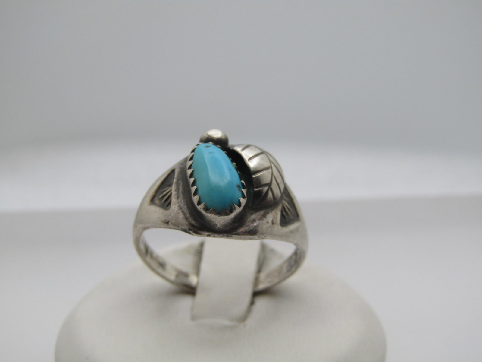 Vintage Sterling Southwestern Turquoise Ring, Sz. 9, Unisex, 1960's-1970's: Vintage Sterling Southwestern Turquoise Ring, Sz. 9, Unisex, 1960's-1970's. This has a 10.5mm by 5.5mm long elongated turquoise ring that is sawtooth bezel-set with a feather and bead accents. It has 