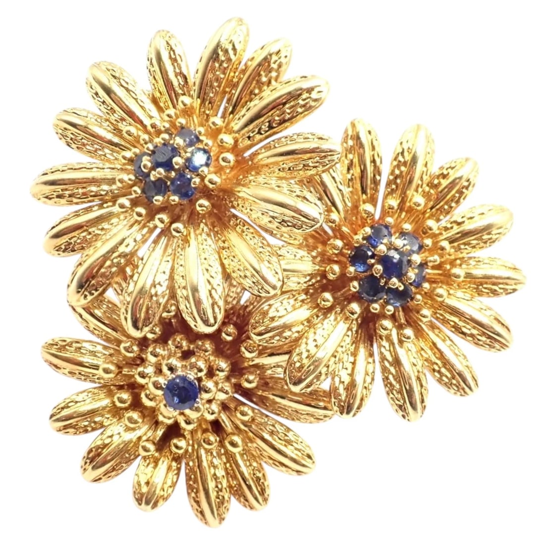 Vintage! Authentic Tiffany & Co. 18k Yellow Gold Sapphire Flower Pin Brooch: Crafted in 18k yellow gold, this Tiffany & Co. flower brooch features three dimensional blooms with finely textured petals. Each flower is centered with vibrant blue sapphires, adding rich contrast. L