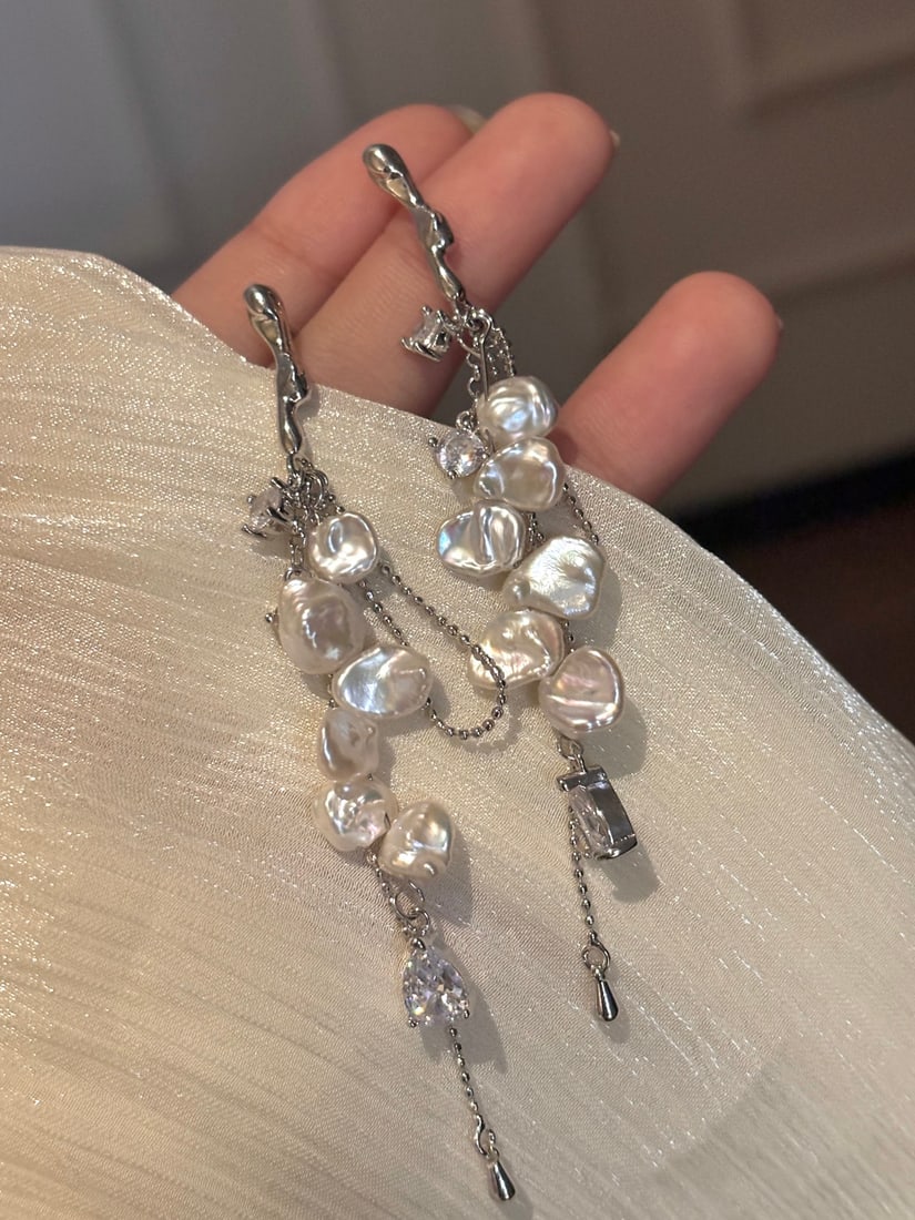 Natural Pearl Earrings: Title: Natural Pearl Earrings Description: These earrings feature natural pearls with a soft luster, complemented by the brilliance of zircon stones, showcasing an exquisite layered look. The tassel