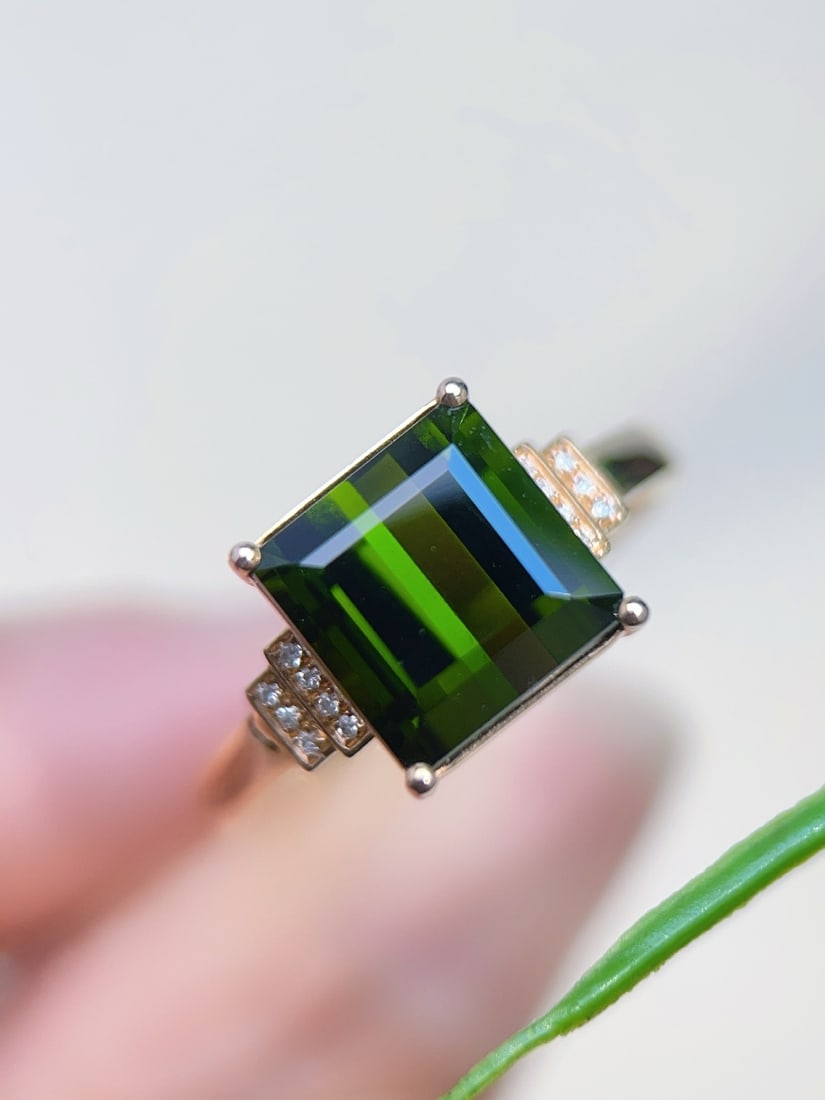 18K Gold Natural Green Tourmaline Ring: Title: 18K Gold Natural Green Tourmaline Ring Description: This ring showcases the serene and vibrant green of the tourmaline, reminiscent of the light in a forest. Its exquisite design is elegant